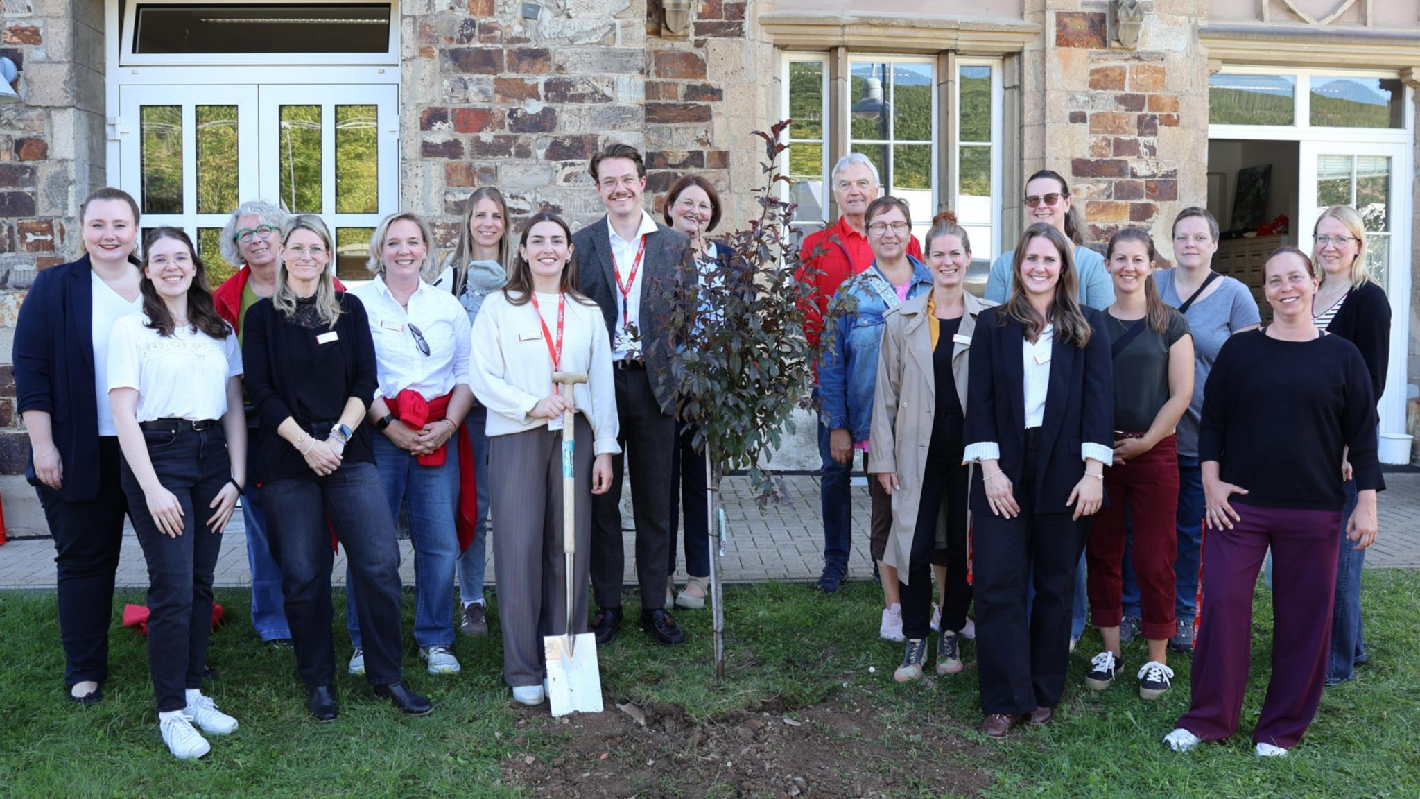 Aktuelle und ehemalige Mitarbeitende der Caritas-Fluthilfe pflanzten gemeinsam einen Baum.