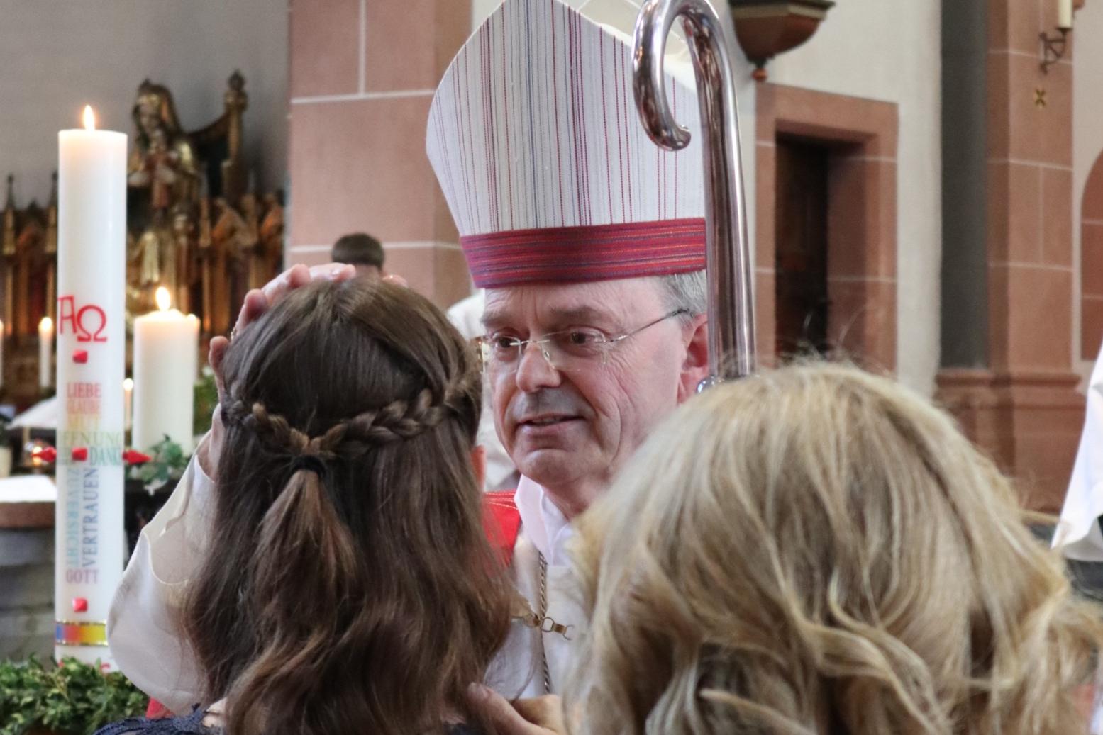 Weihbischof Brahm spendet einer jungen Frau das Sakrament der Firmung